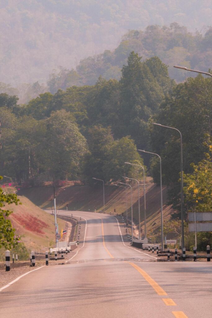 The scene of the road at the dam, with the mountains in the background and a light pole. Stock Free