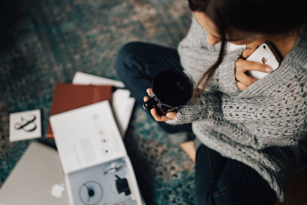 Woman reading magazines on the floor while enjoying her cup of tea Stock Free