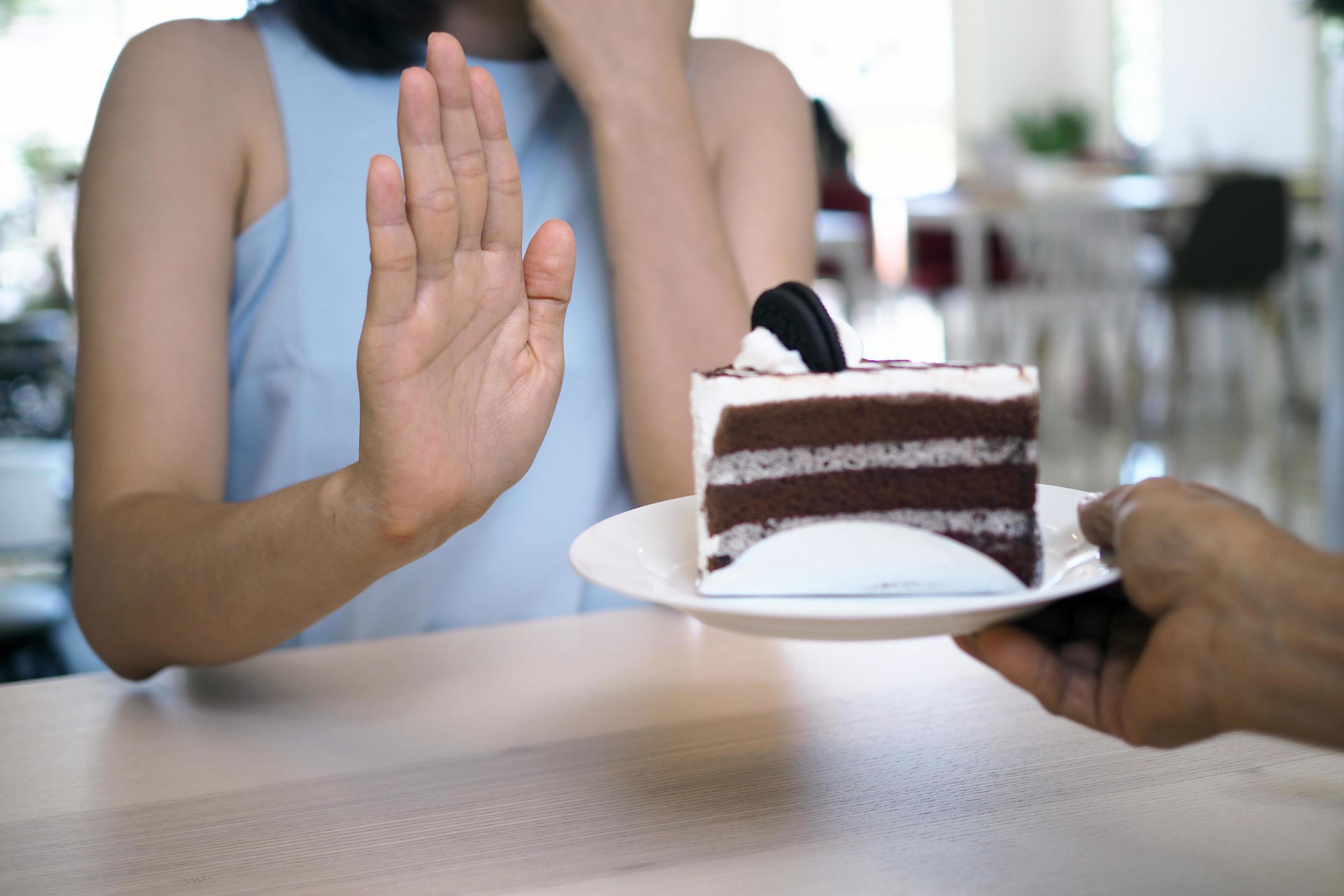 One of the health-care girls used a hand to push a plate of chocolate cake. Refuse to eat foods that contain Trans Fat. Stock Free