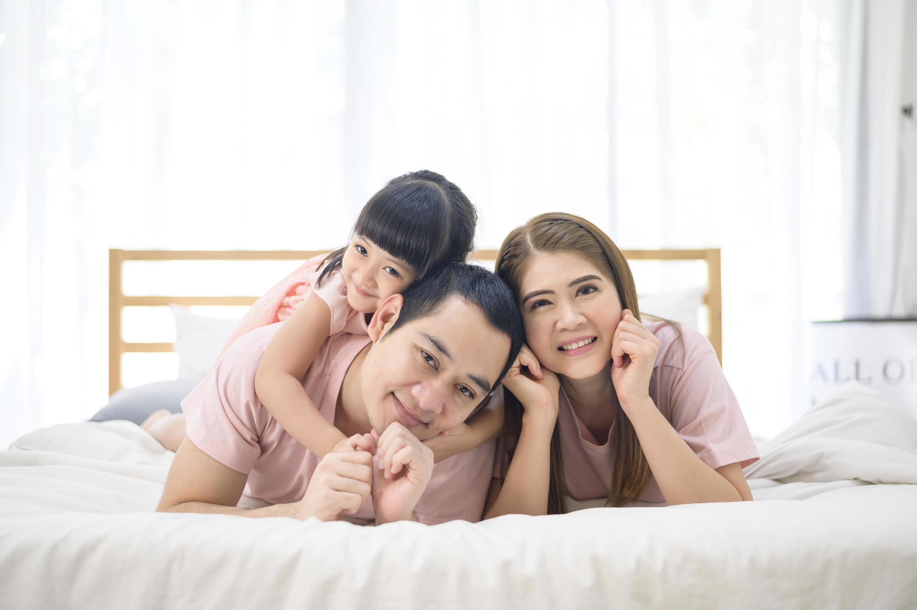 portrait of happy Asian family in white bedroom Stock Free