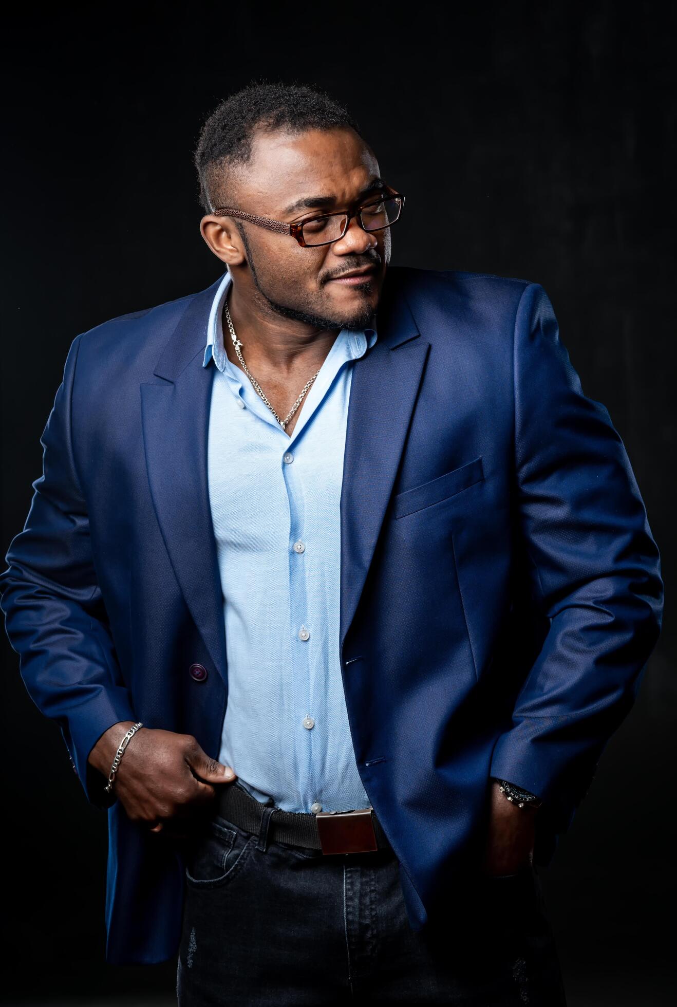 Studio portrait of a charming black businessman dressed in suit. Fashion portrait on black background. Closeup. Stock Free