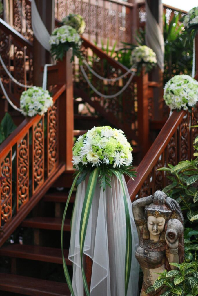 White flowers bouquet decorative on railing stair and garden of Thai wooden house for wedding ceremony. Stock Free