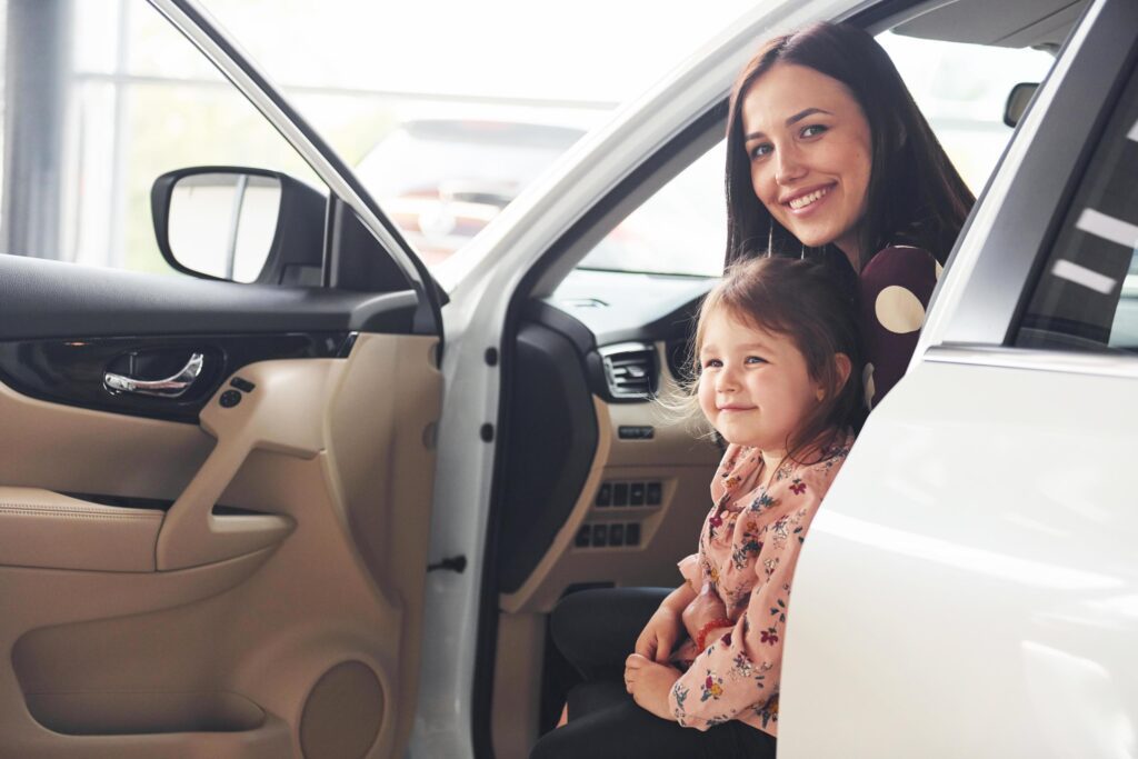 Mother with her daughter inside of modern automobile together Stock Free