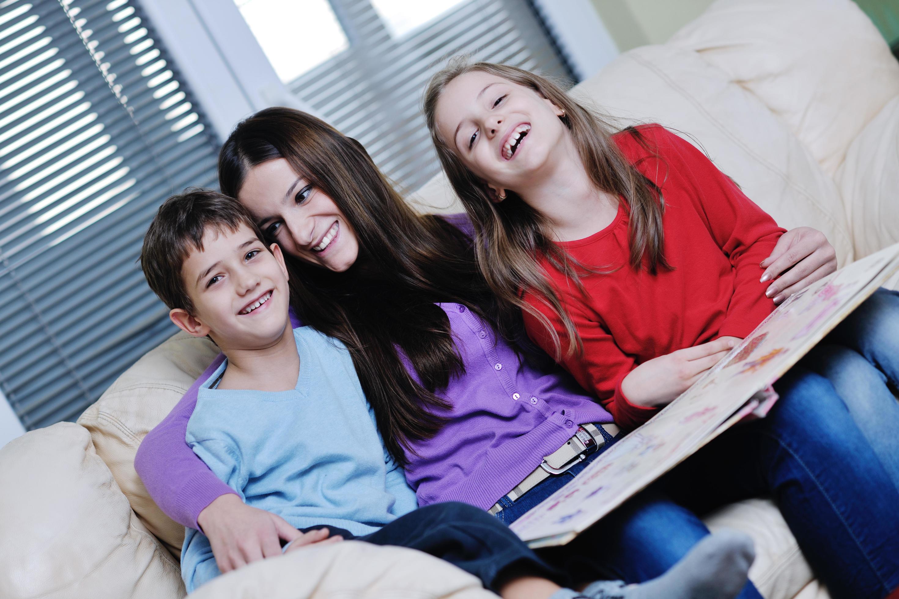 young mom play with their kids at home and reading book Stock Free