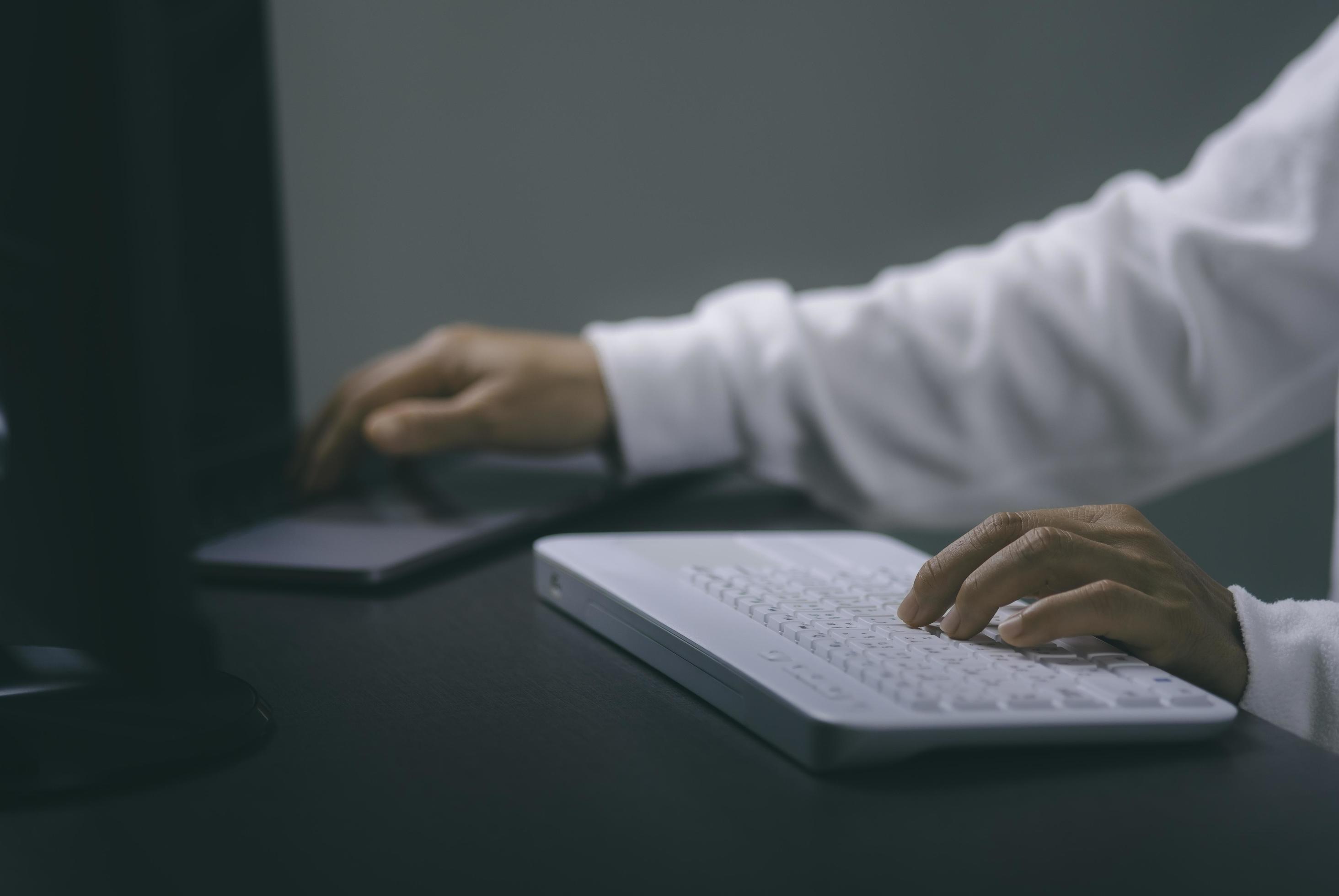 
									Young woman working in front of the computer on the desk Stock Free