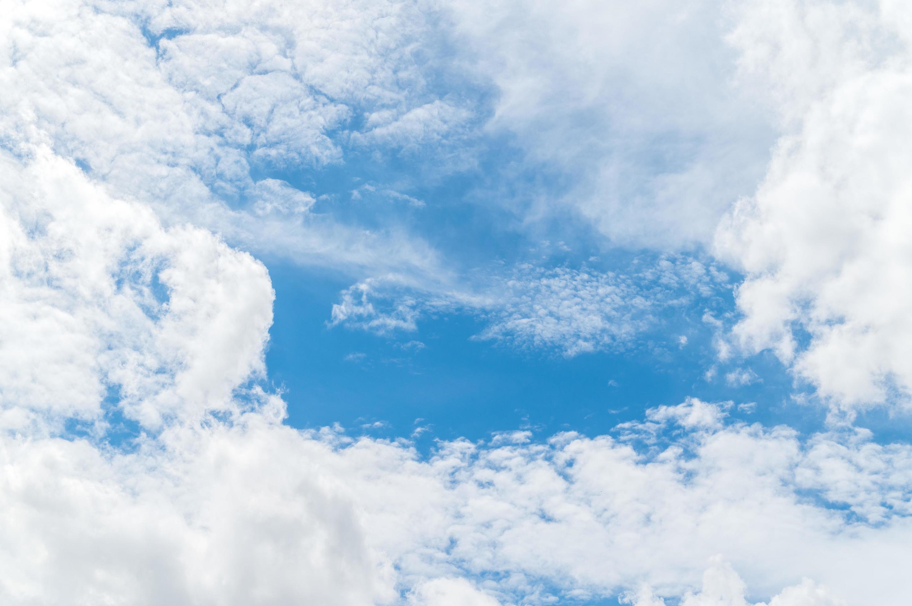 Nature background from white clouds in sunny day. Beautiful white fluffy clouds in blue sky. Stock Free