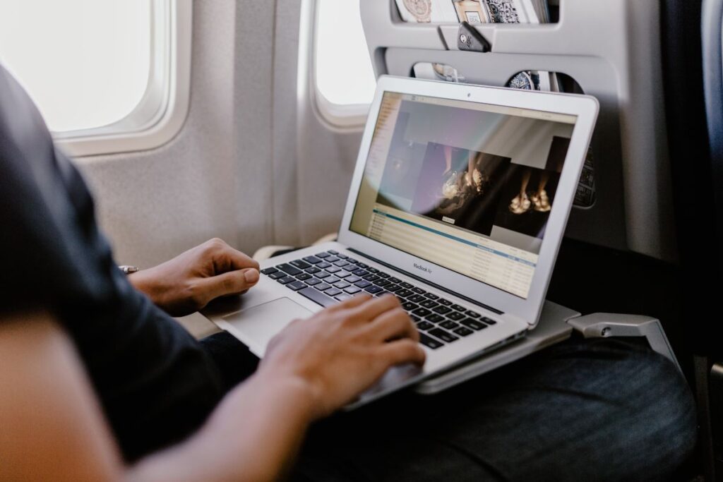 
									Unrecognizable man with notebook sitting inside an airplane Stock Free