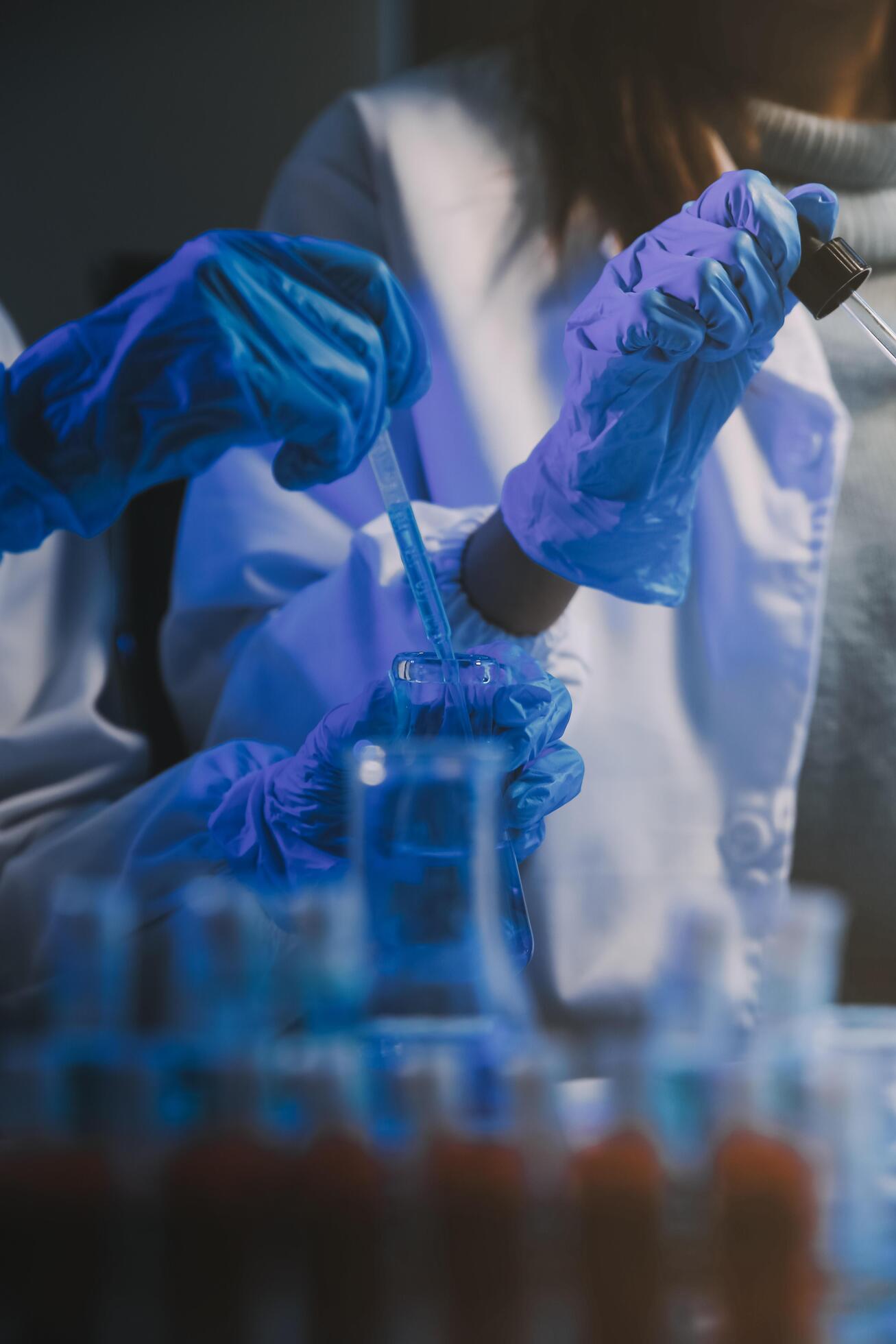 chemist,scientist hand dropping chemical liquid into test tube, science research and development concept Stock Free