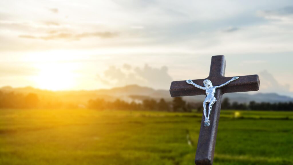 A red wooden cross on a blurred cemetery background. Stock Free