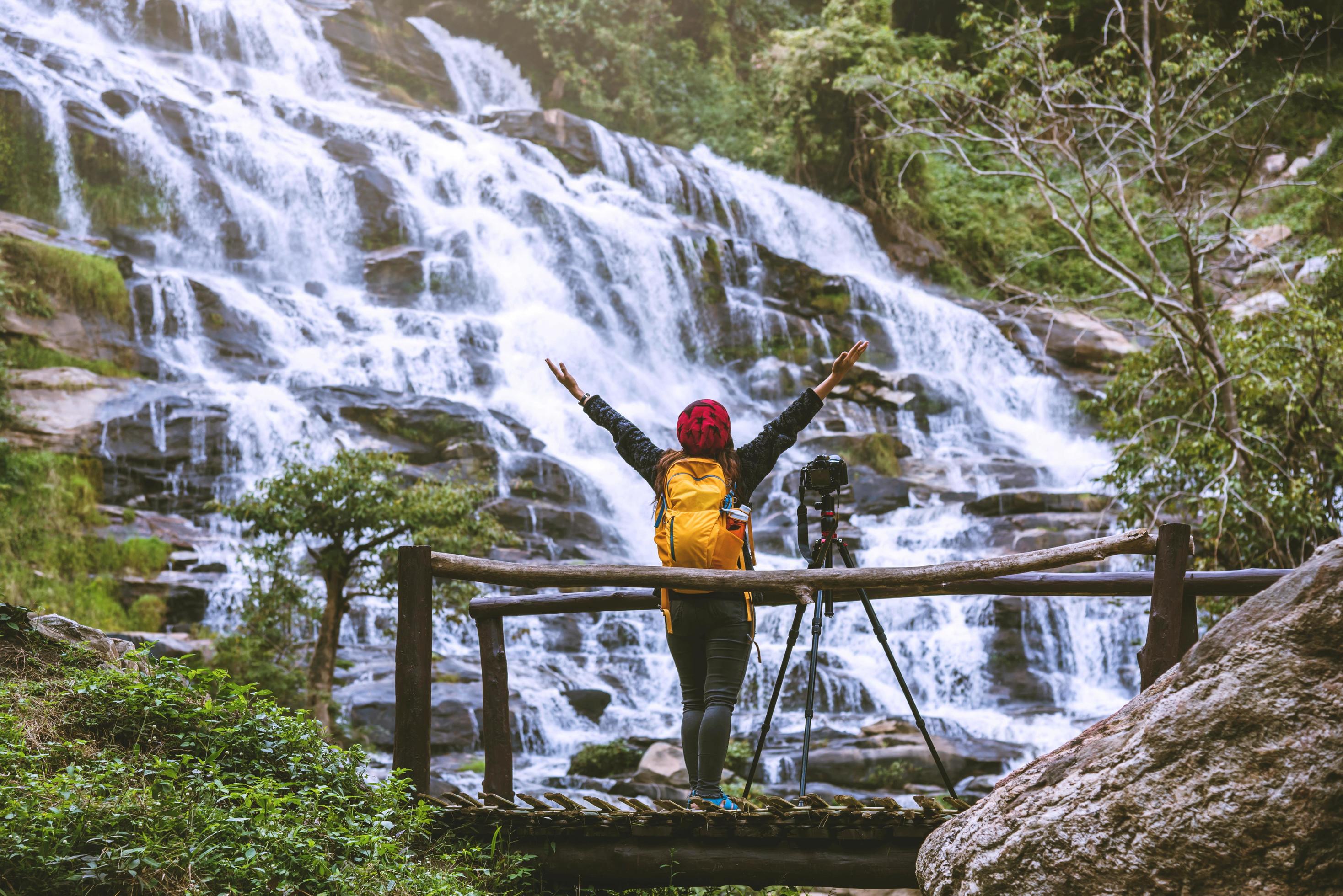 Asian woman travel relax to photograph the waterfalls beautiful. In the winter. at the waterfall mae ya chiangmai in thailand. travel nature. summer Stock Free