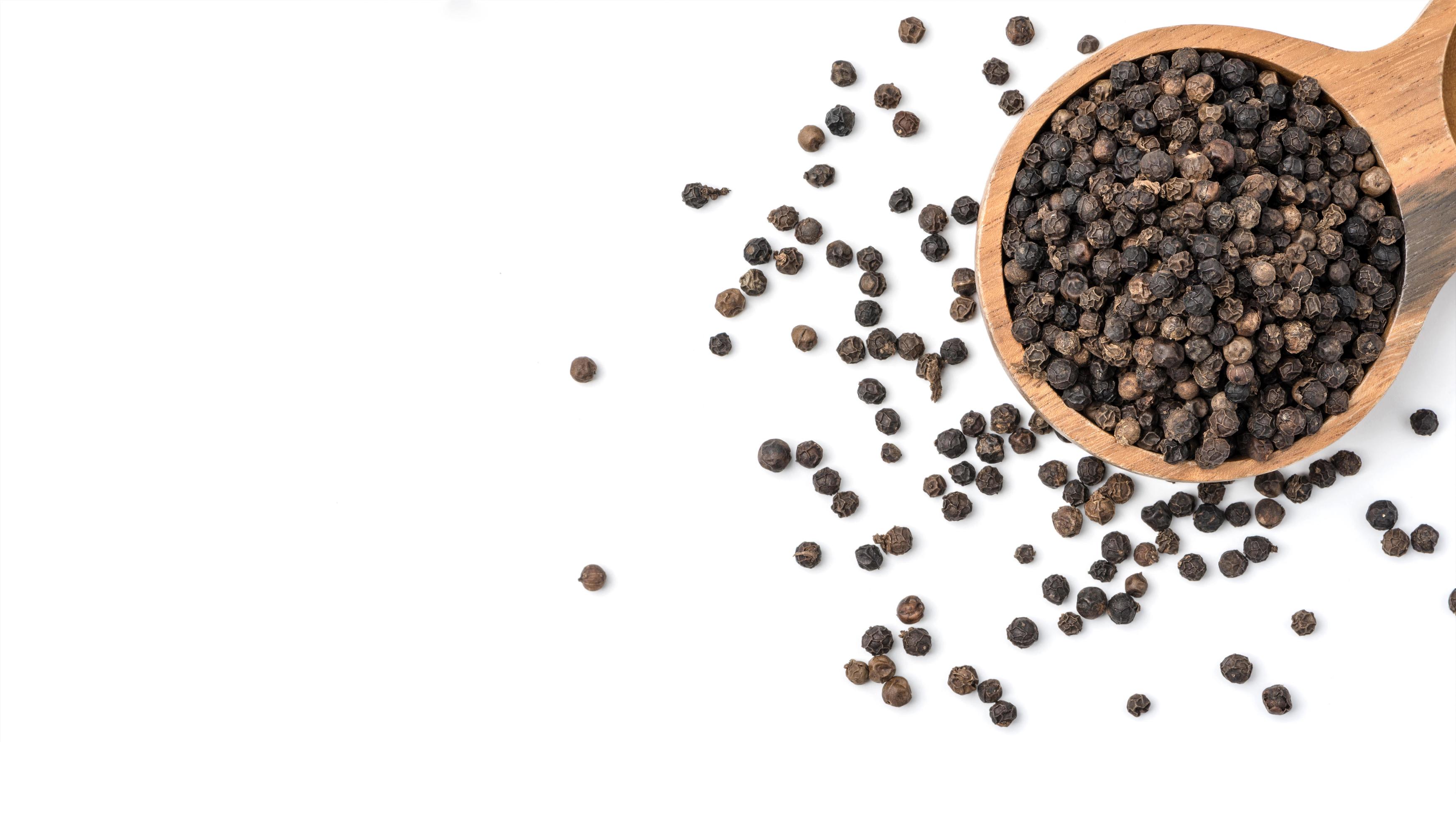 Black pepper seeds on white background. Food ingredients, spices Stock Free