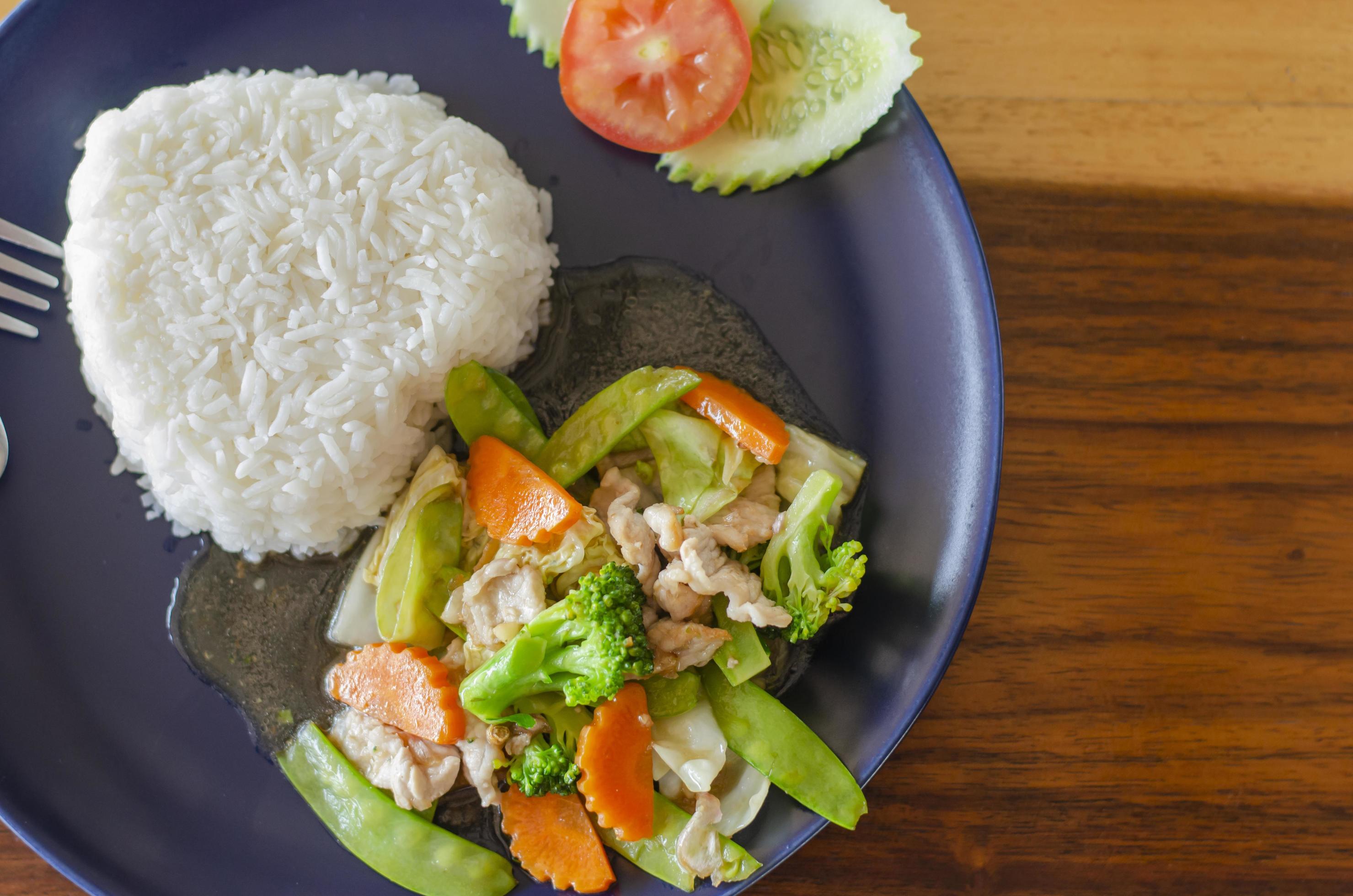 Stir fried mixed vegetables with pork or chicken tasty food, healthy food from Thailand Asia with wooden table background. Top view Stock Free