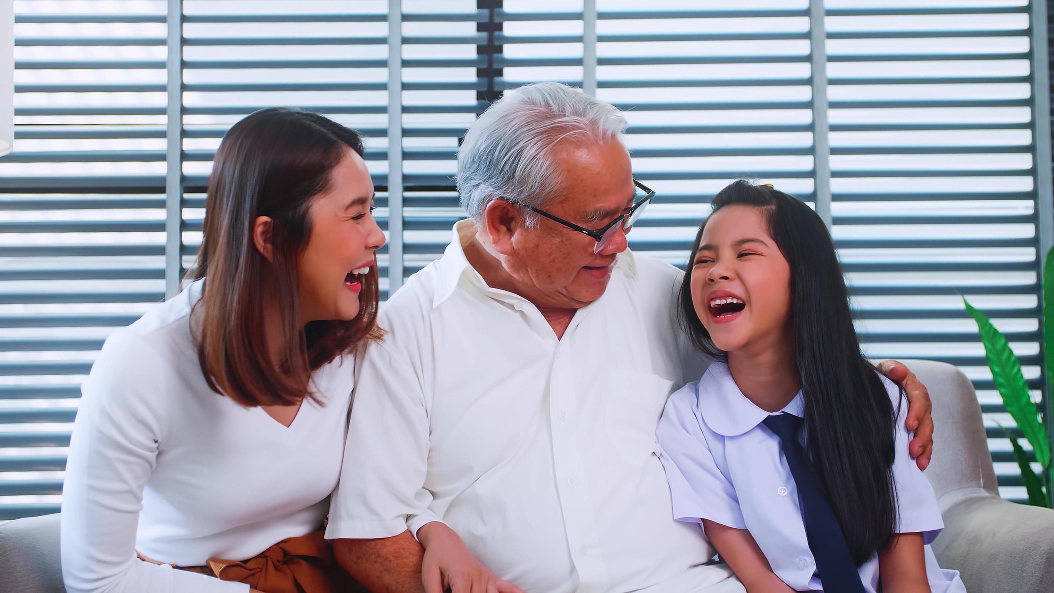 Happy family with grandfather, mother and little daughter spending time together in living room. Stock Free