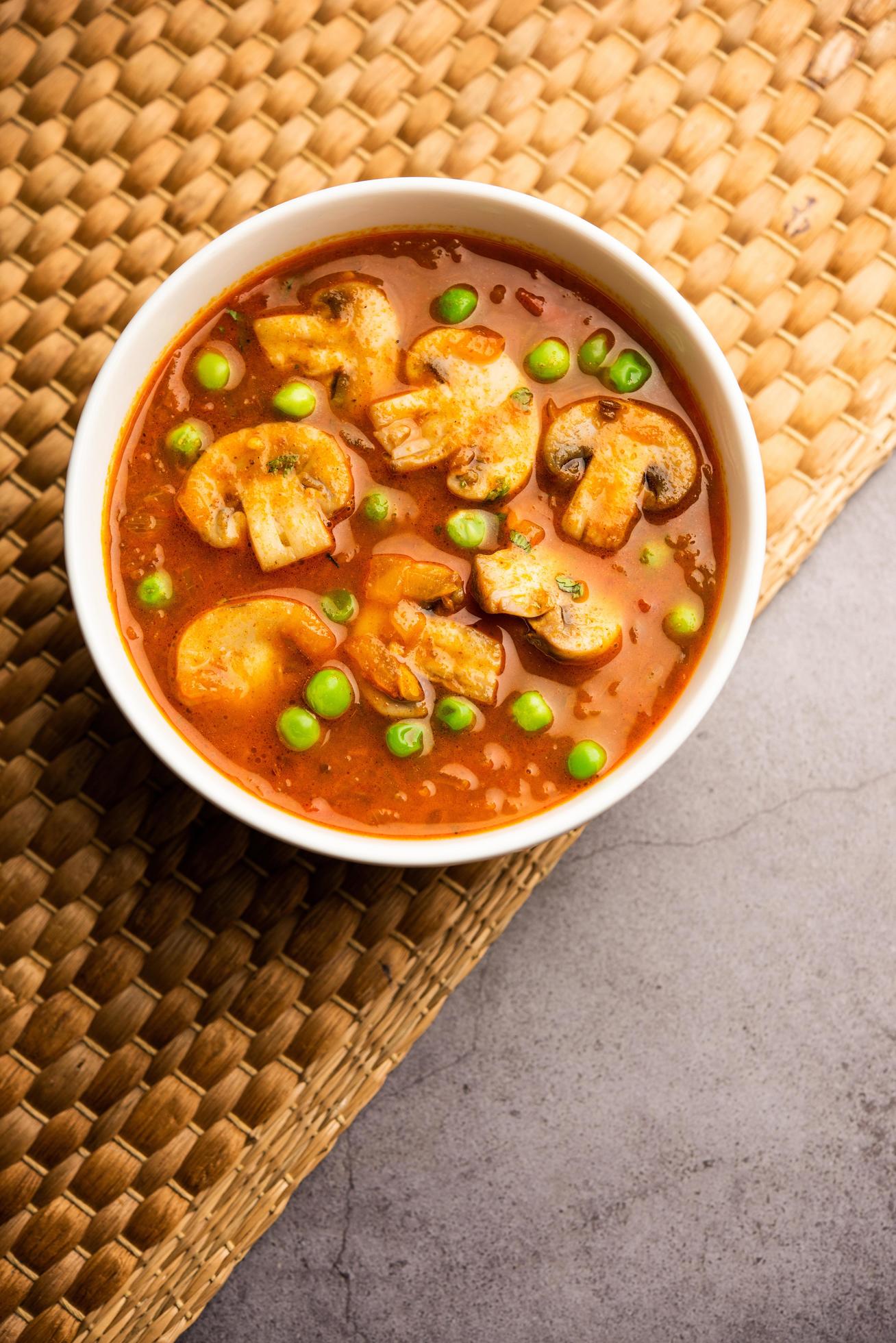 Mushroom and Pea Curry with Roasted Garlic, Indian food served in a bowl Stock Free