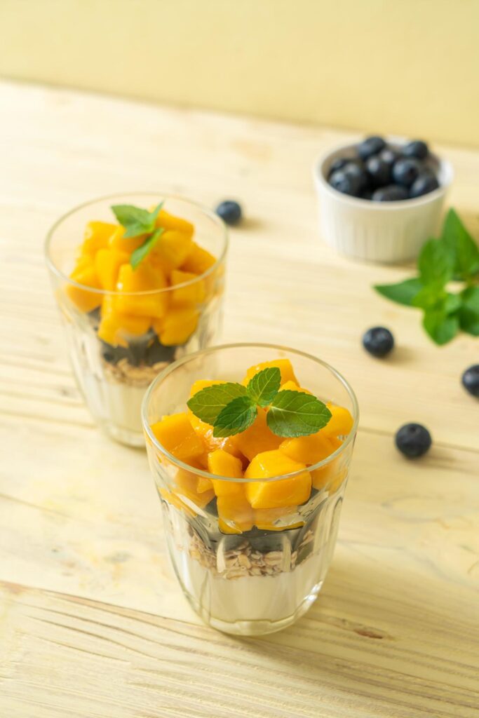 Homemade fresh mango and fresh blueberry with yogurt and granola – healthy food style Stock Free