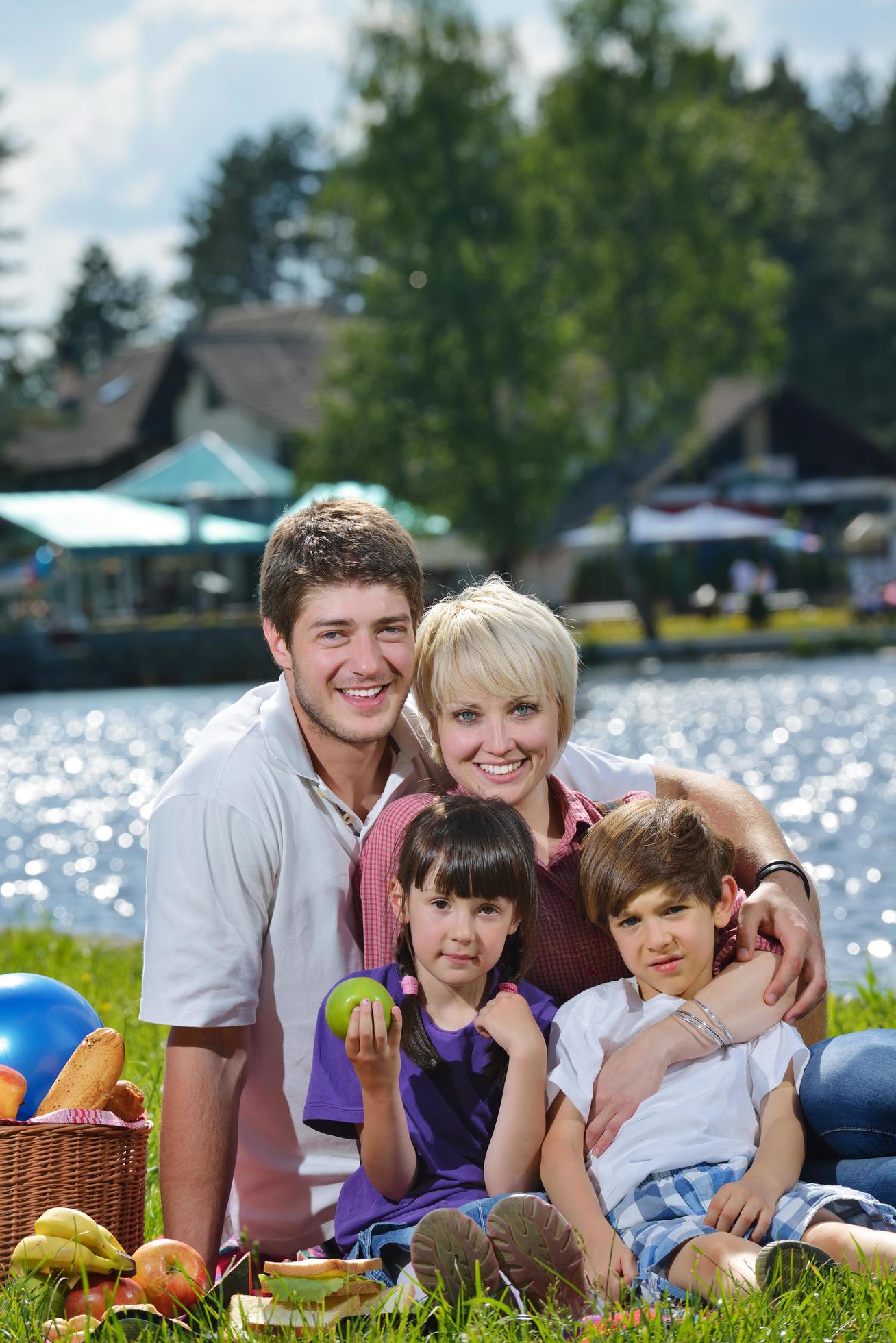 Happy family playing together in a picnic outdoors Stock Free