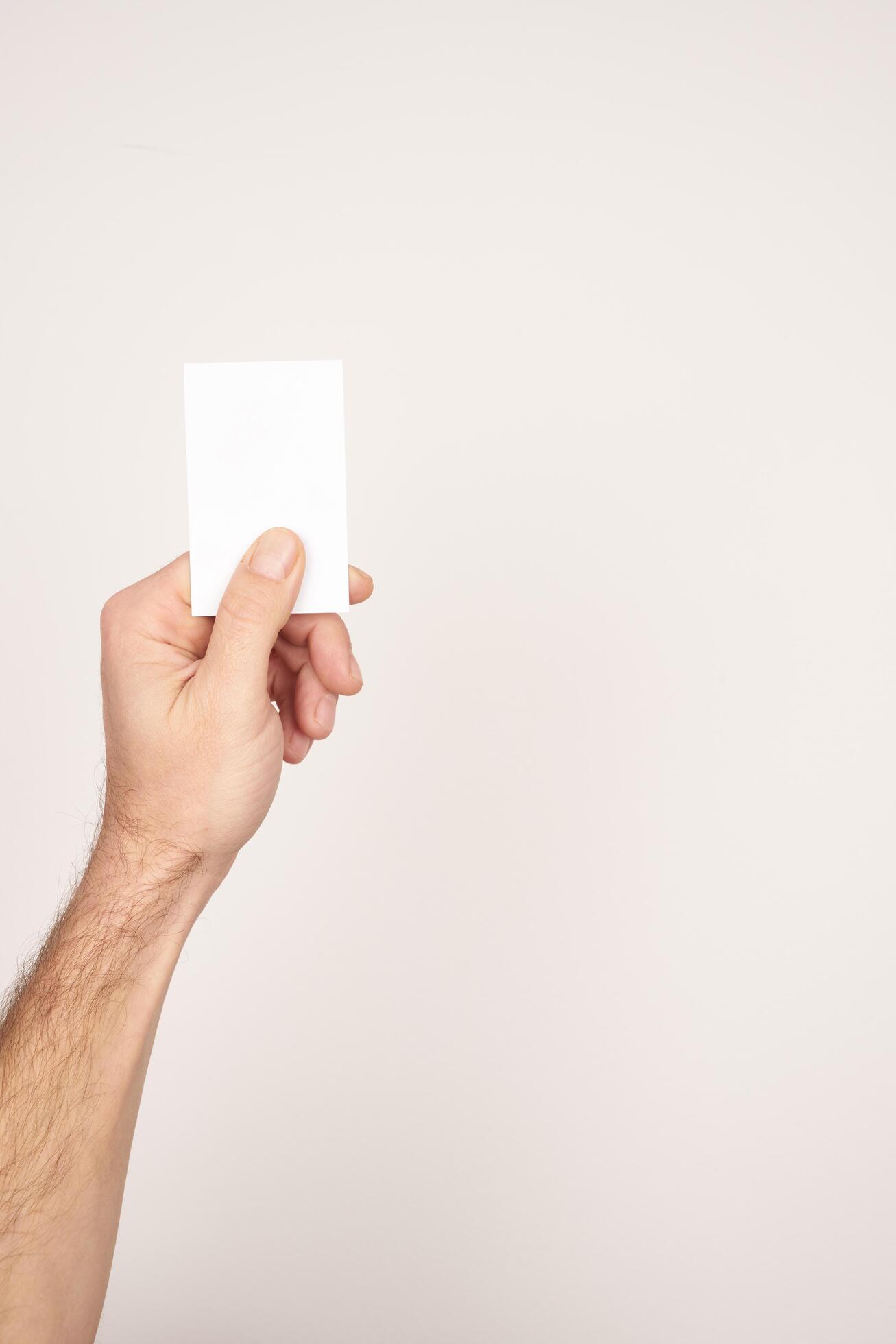 Male hand holding and giving a white blank business card Stock Free