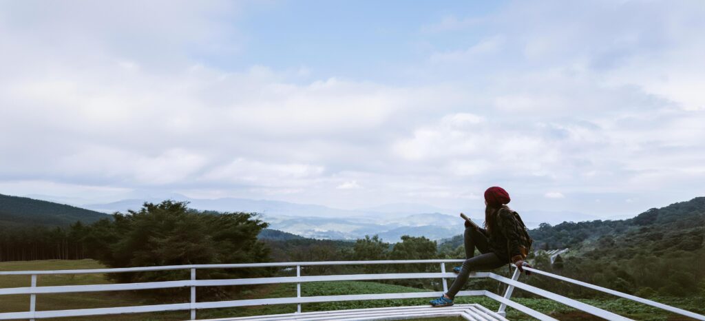 The girl is sitting relaxing at the natural mountain viewpoint and writing a record of her winter travel. smiled happy writing a diary. Stock Free