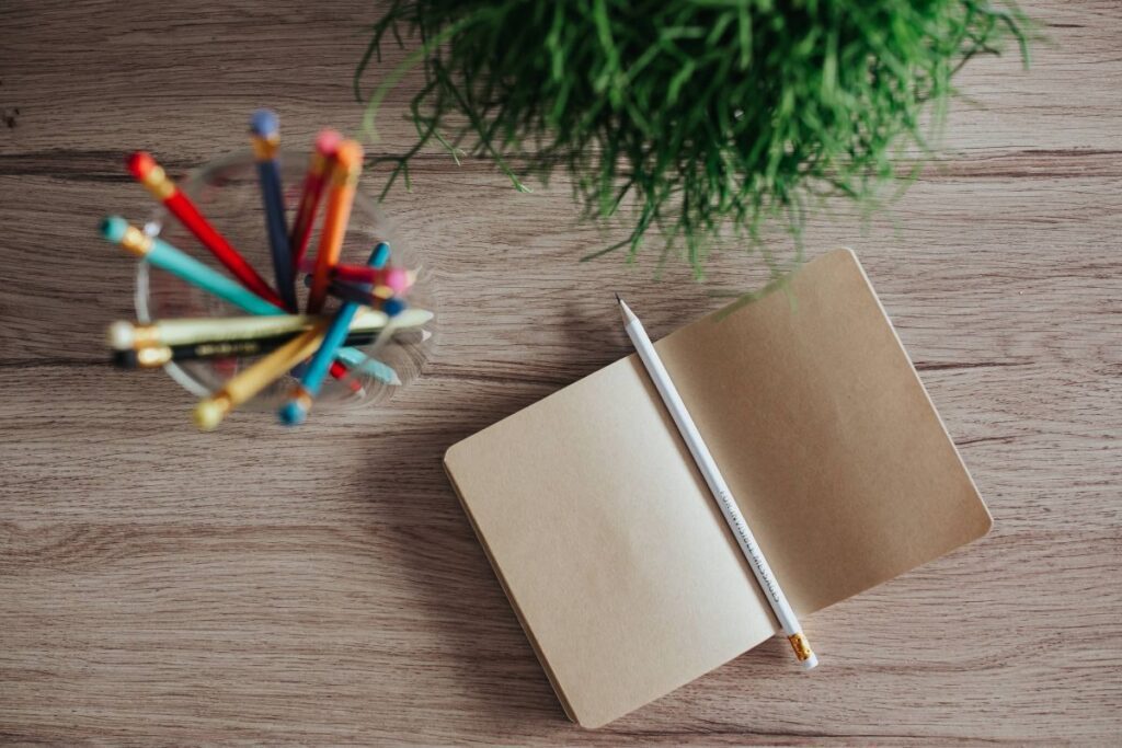 Notebooks with colourful pencils on a wooden desk Stock Free