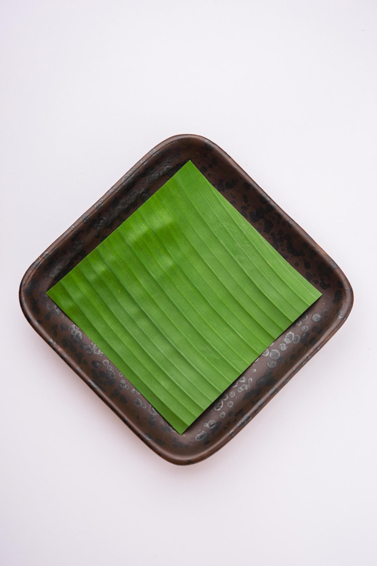 banana leaf on blank plate for edit food or subject on Stock Free