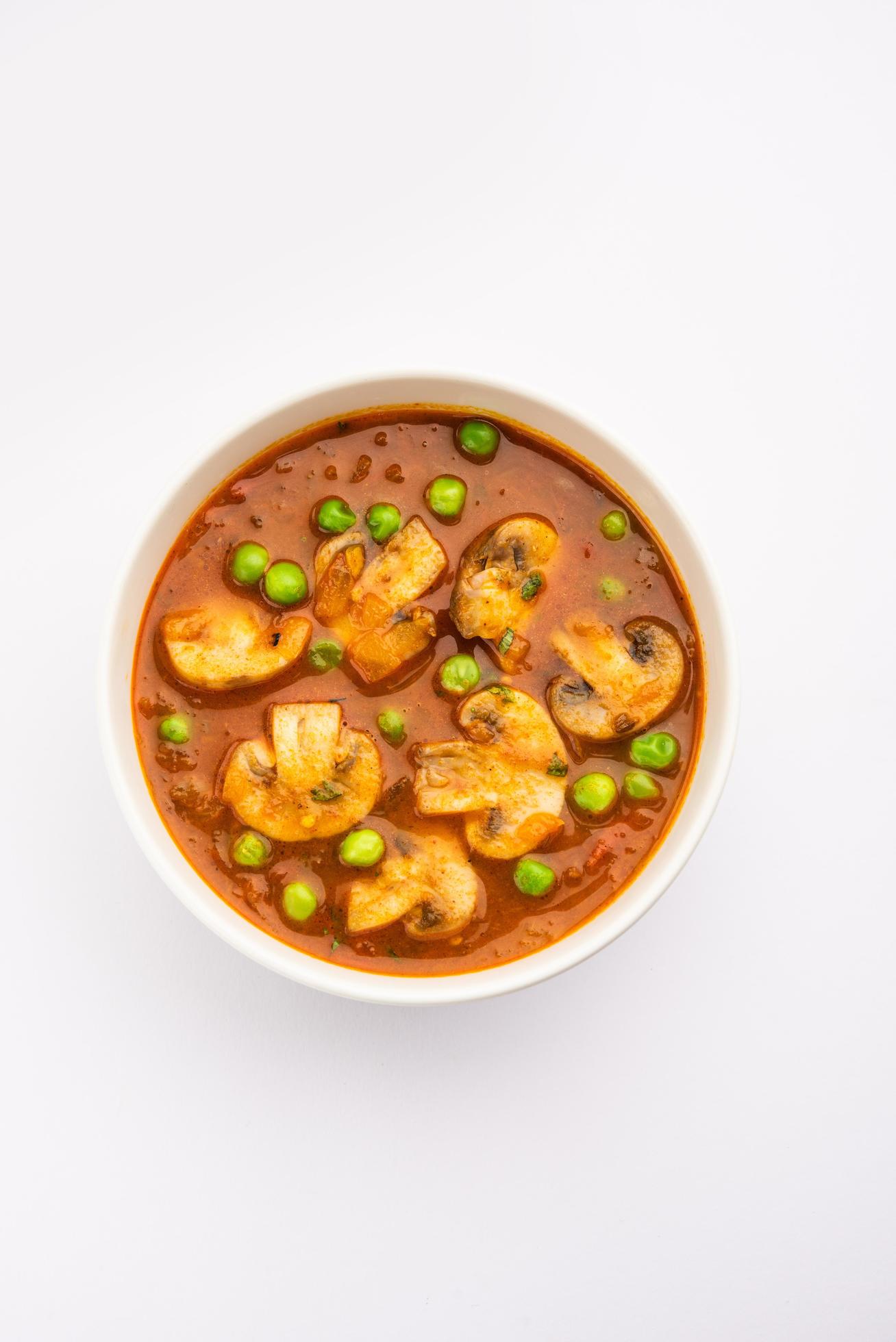 Mushroom and Pea Curry with Roasted Garlic, Indian food served in a bowl Stock Free