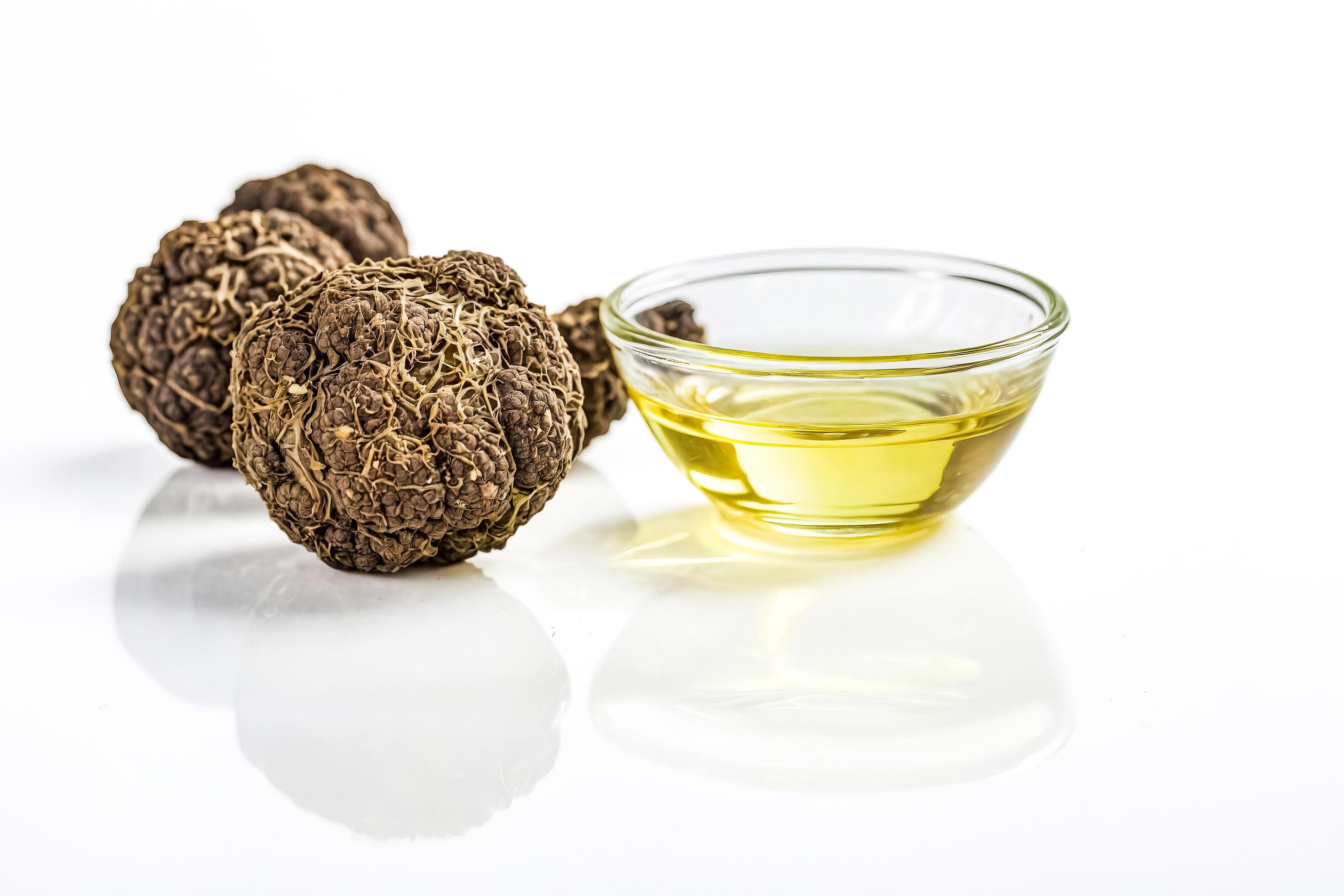 Dried Morel Mushrooms and Oil in a Small Glass Bowl on White Background Stock Free