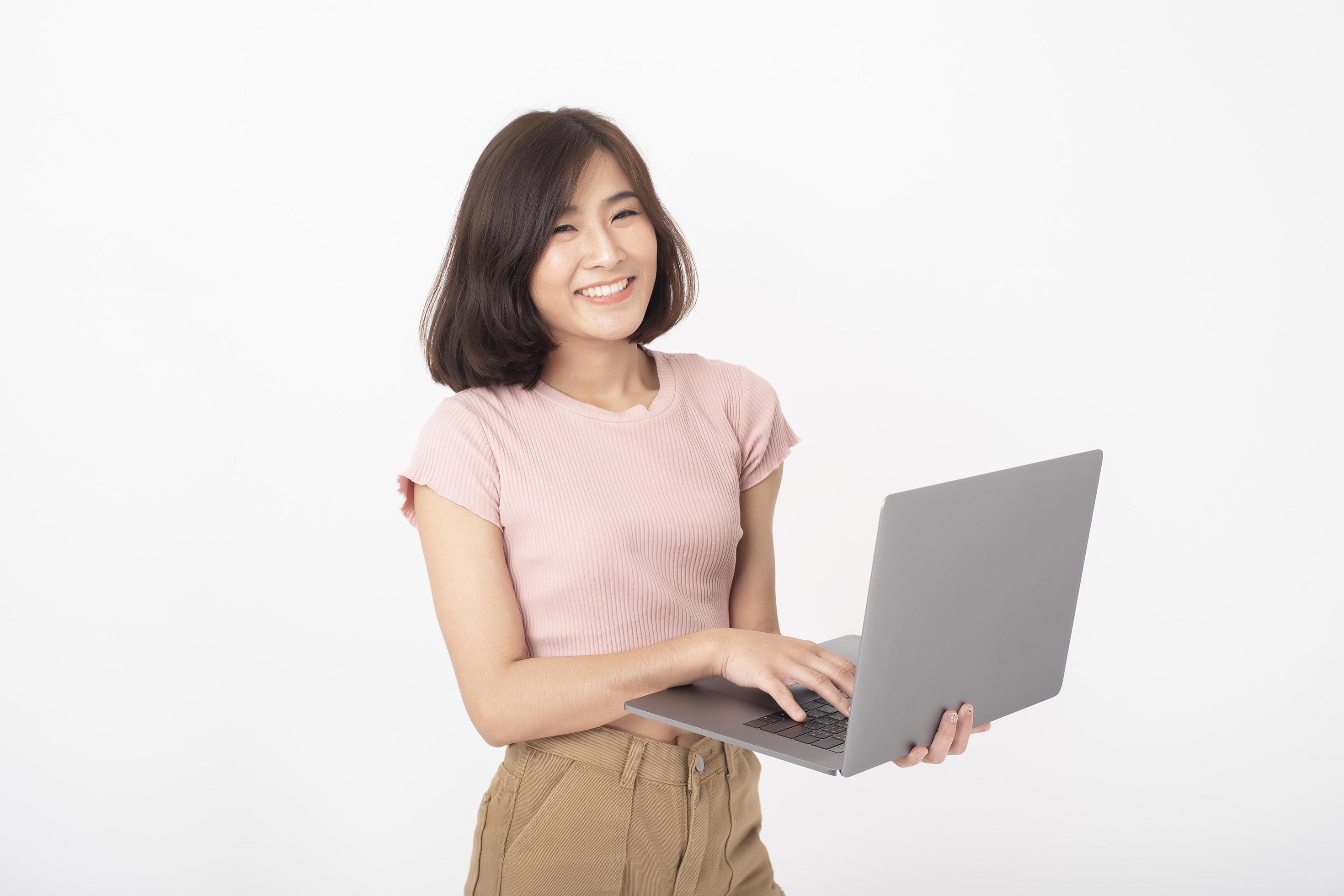 
									Cute Asian teen woman is working with computer on white background Stock Free