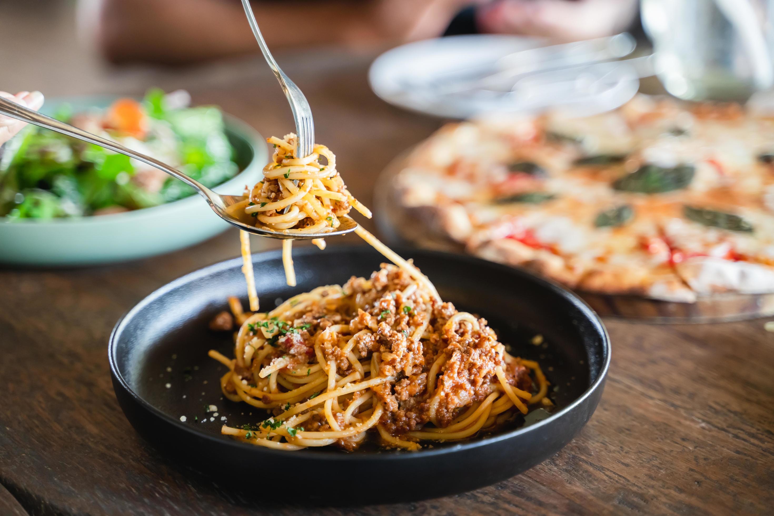 Eating food. people eating Italian food Pasta, Pizza, Salad on the table. Stock Free