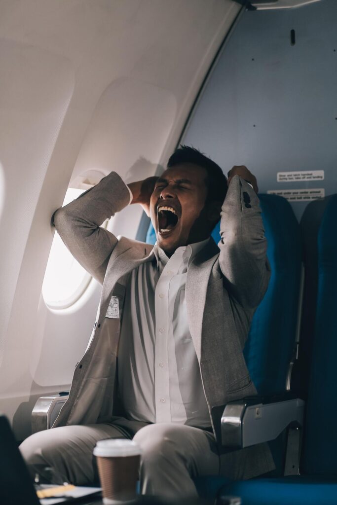 Stressed and professional Asian businessman in a business class, having a serious phone call with someone during the flight to a business meeting. Stock Free