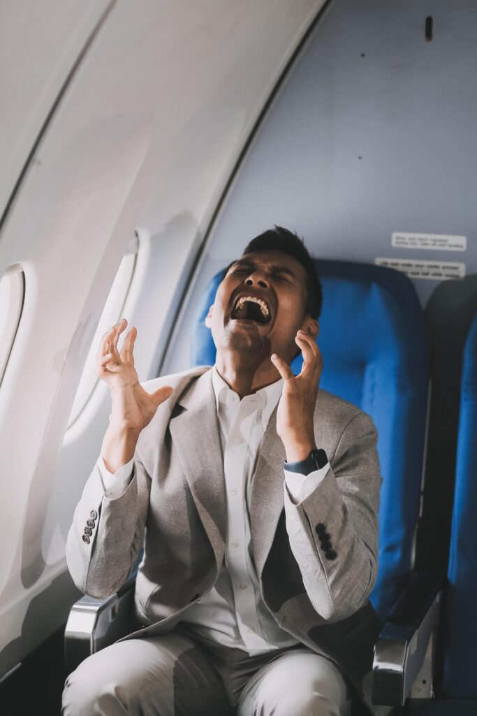 Stressed and professional Asian businessman in a business class, having a serious phone call with someone during the flight to a business meeting. Stock Free