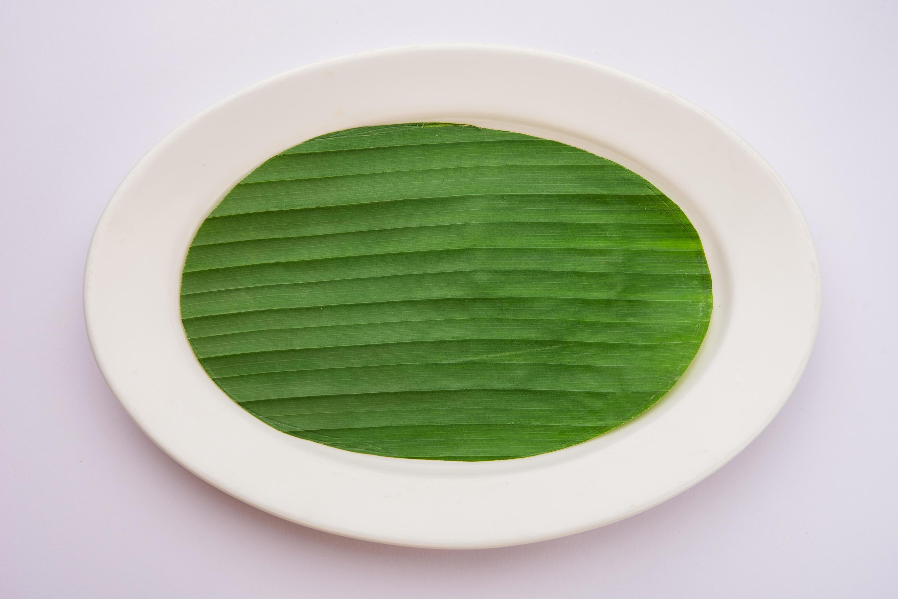 banana leaf on blank plate for edit food or subject on Stock Free