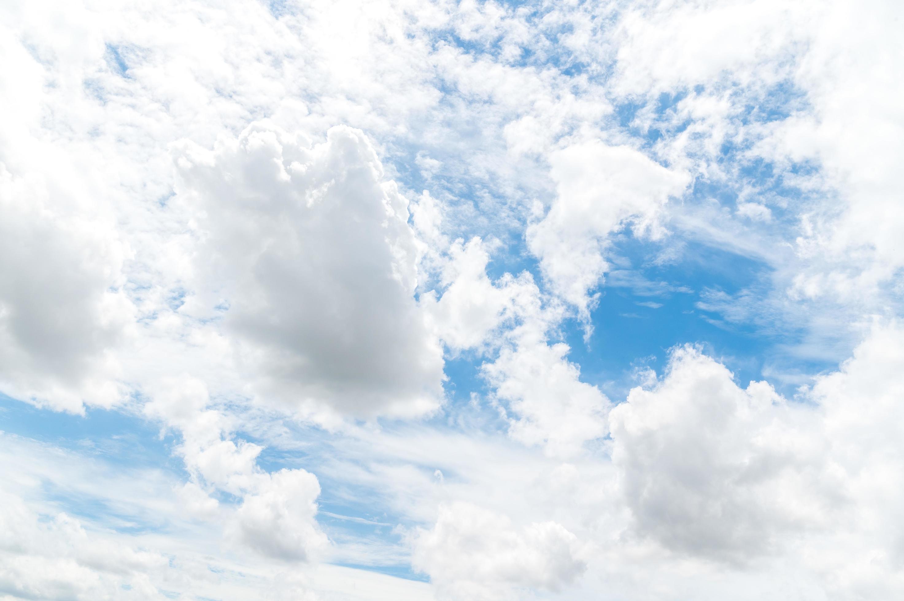 Nature background from white clouds in sunny day. Beautiful white fluffy clouds in blue sky. Stock Free