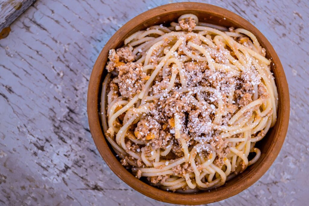 Bowl of Spaghetti with Minced Meat on a Broken Paint Wooden Background Stock Free