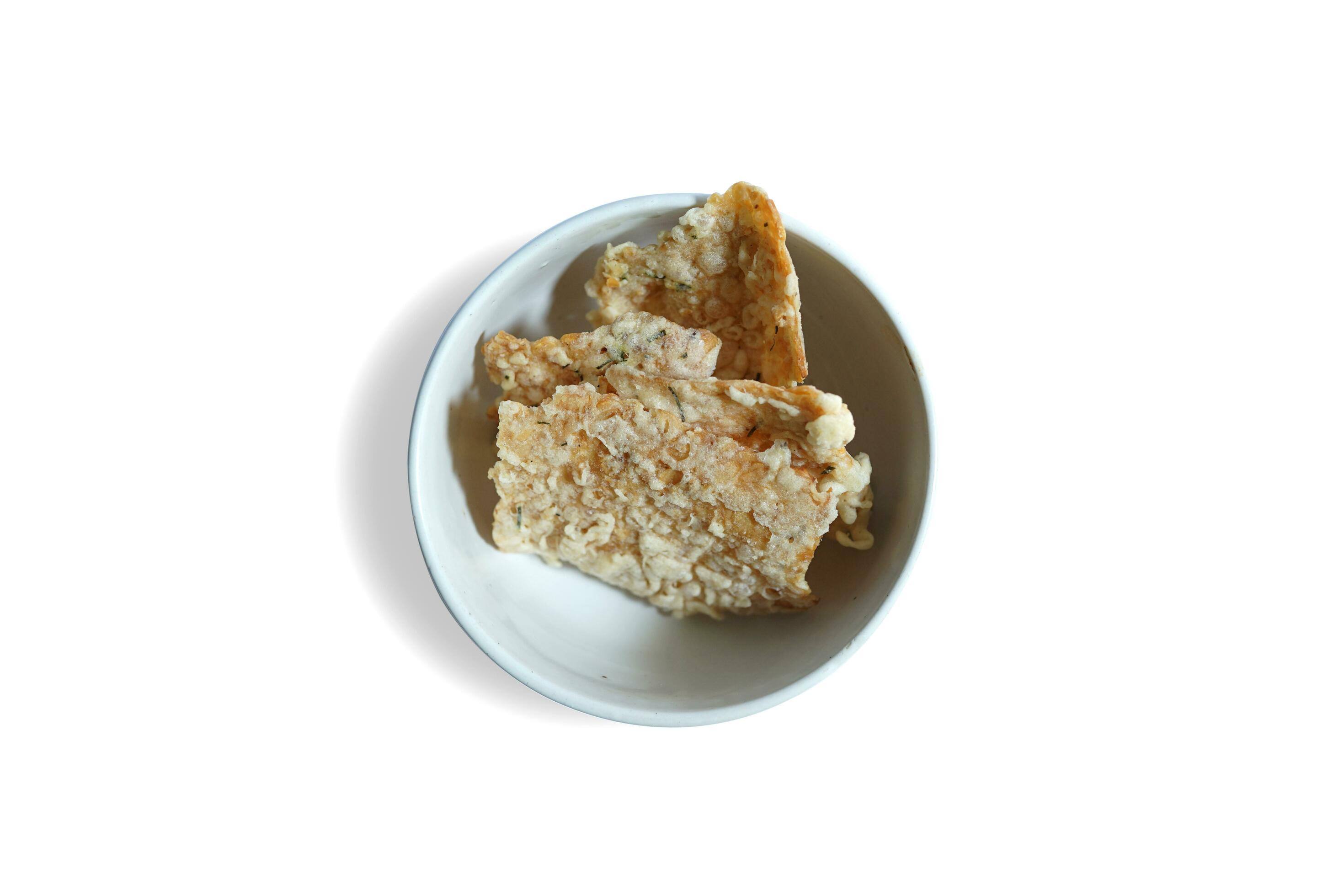 savory snack, tempeh chips in a white bowl on a white background – Indonesian street food Stock Free