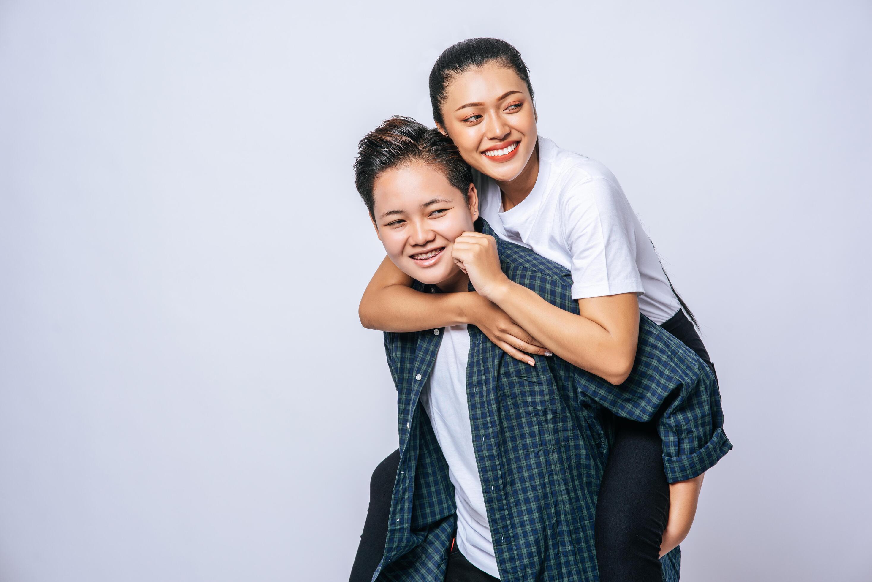 Two loving women wore striped shirts and rode their backs. Stock Free