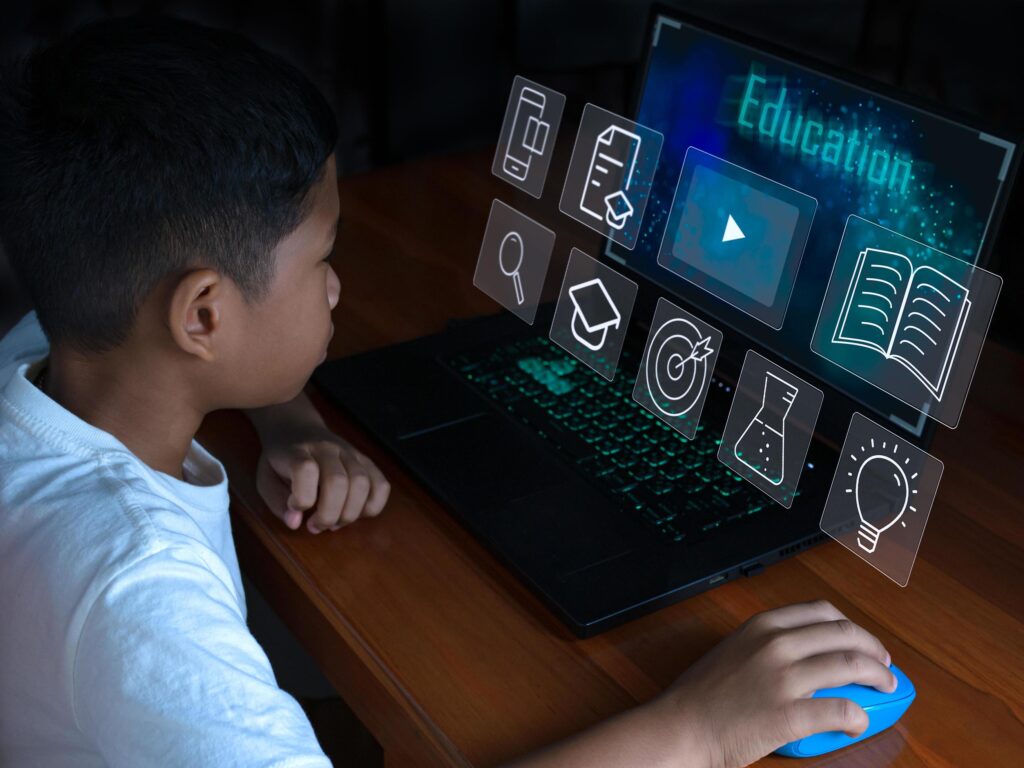 Close up The boy sits staring at the laptop and his hand is holding the mouse. educational concept, educational information search, copy space Stock Free