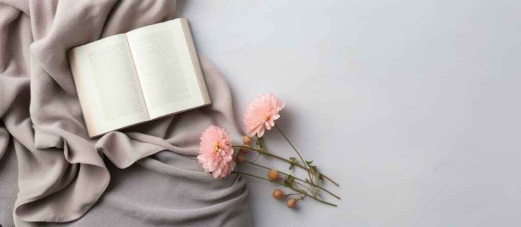 An open book and some flowers on a blanket created with Generative AI technology Stock Free