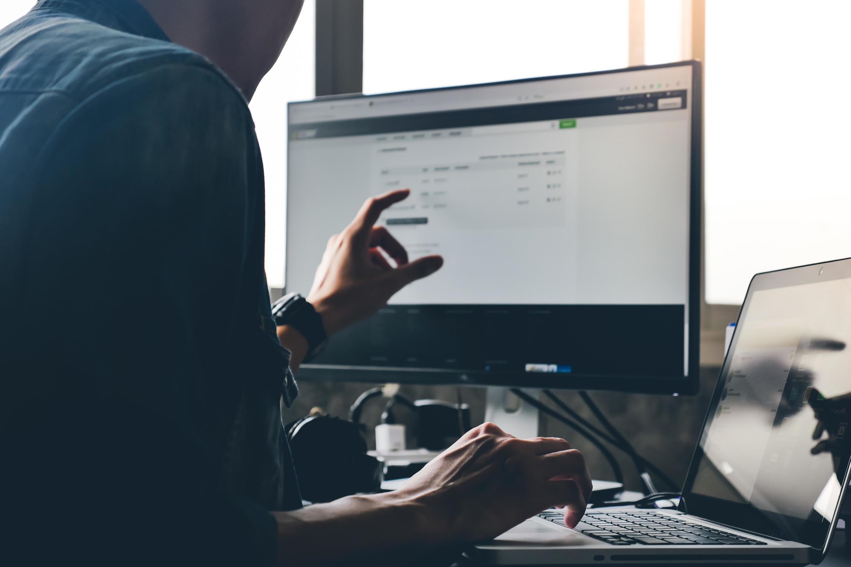 Casual man using computer on the desk. Stock Free