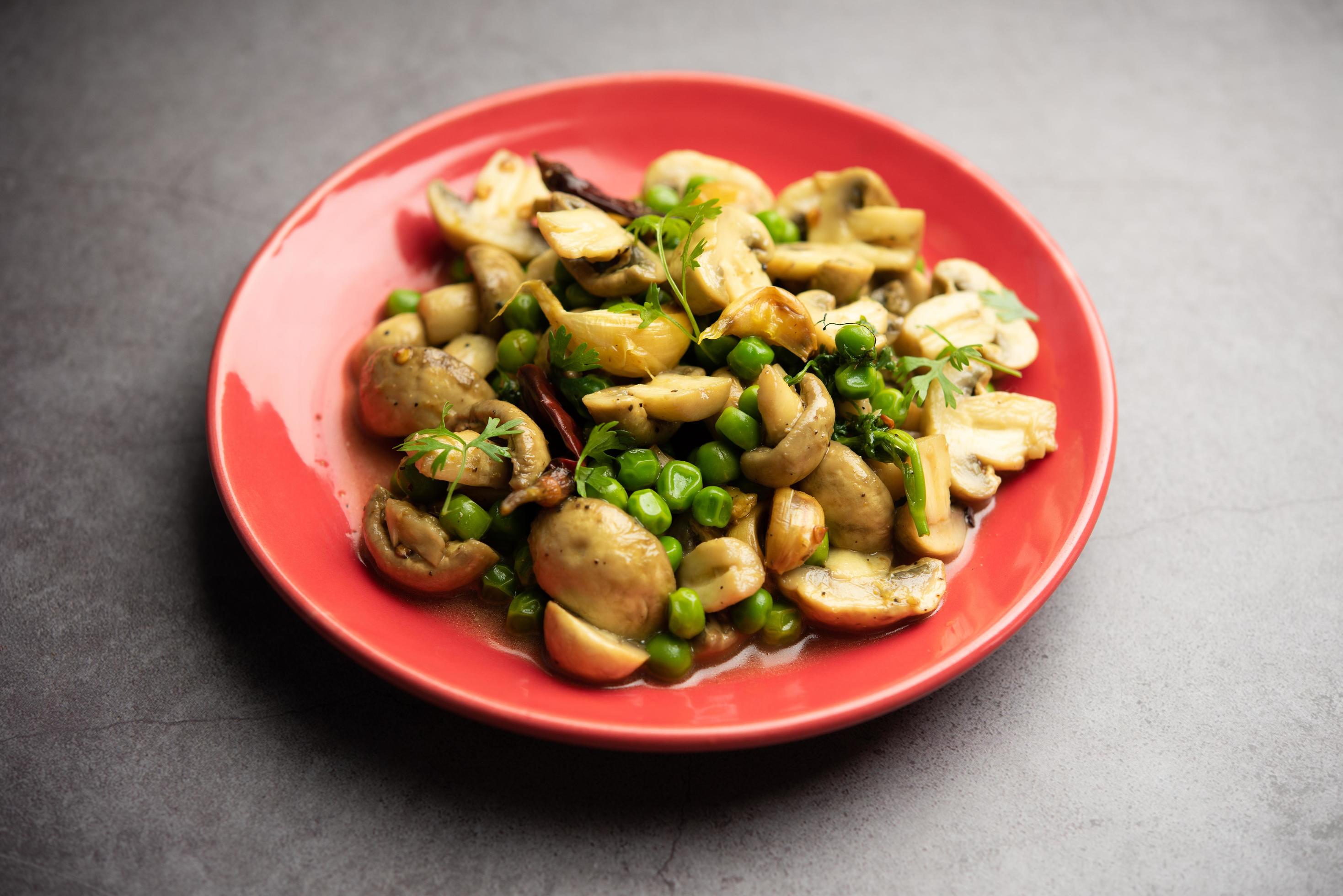 Mushroom and Pea Curry with Roasted Garlic, Indian food served in a bowl Stock Free