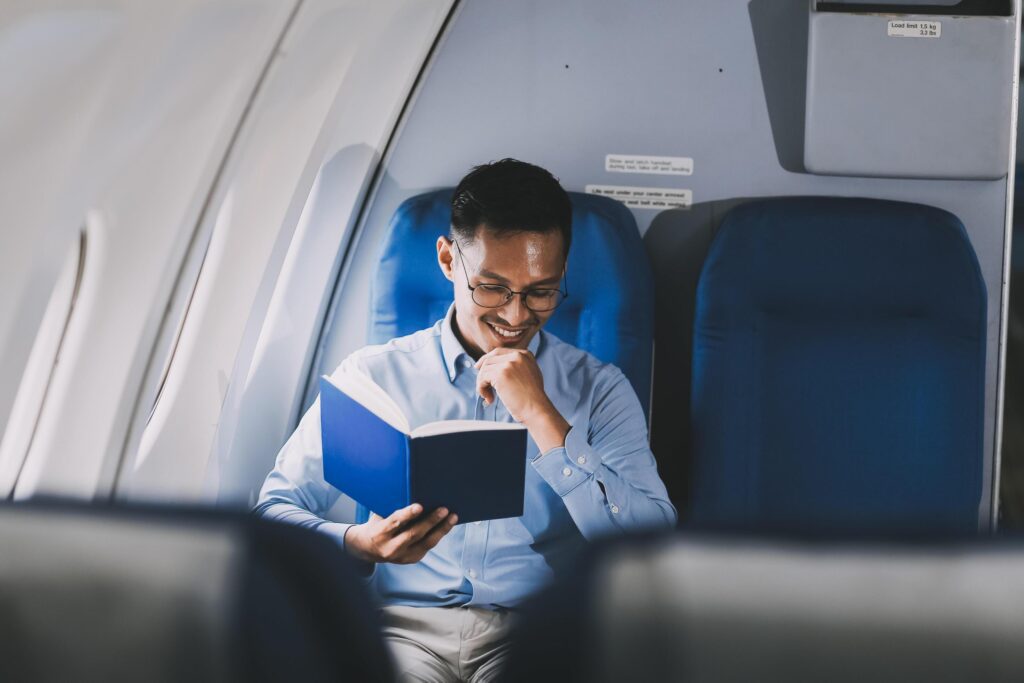 Airplane, travel and portrait of businessman working on laptop computer and smartphone while sitting in airplane. Stock Free