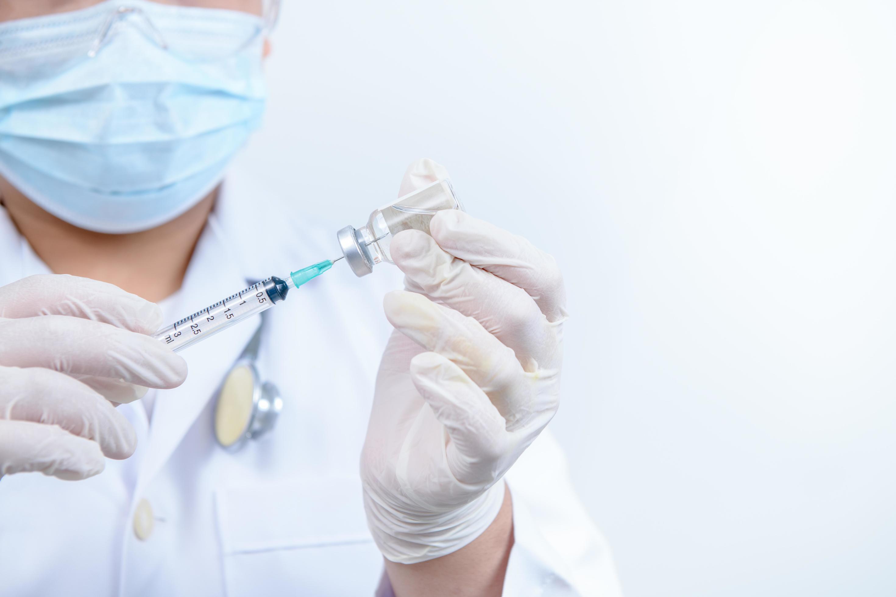 Doctor or scientist in gown shirt holding a syringe with liquid vaccines. medical and science concept Stock Free