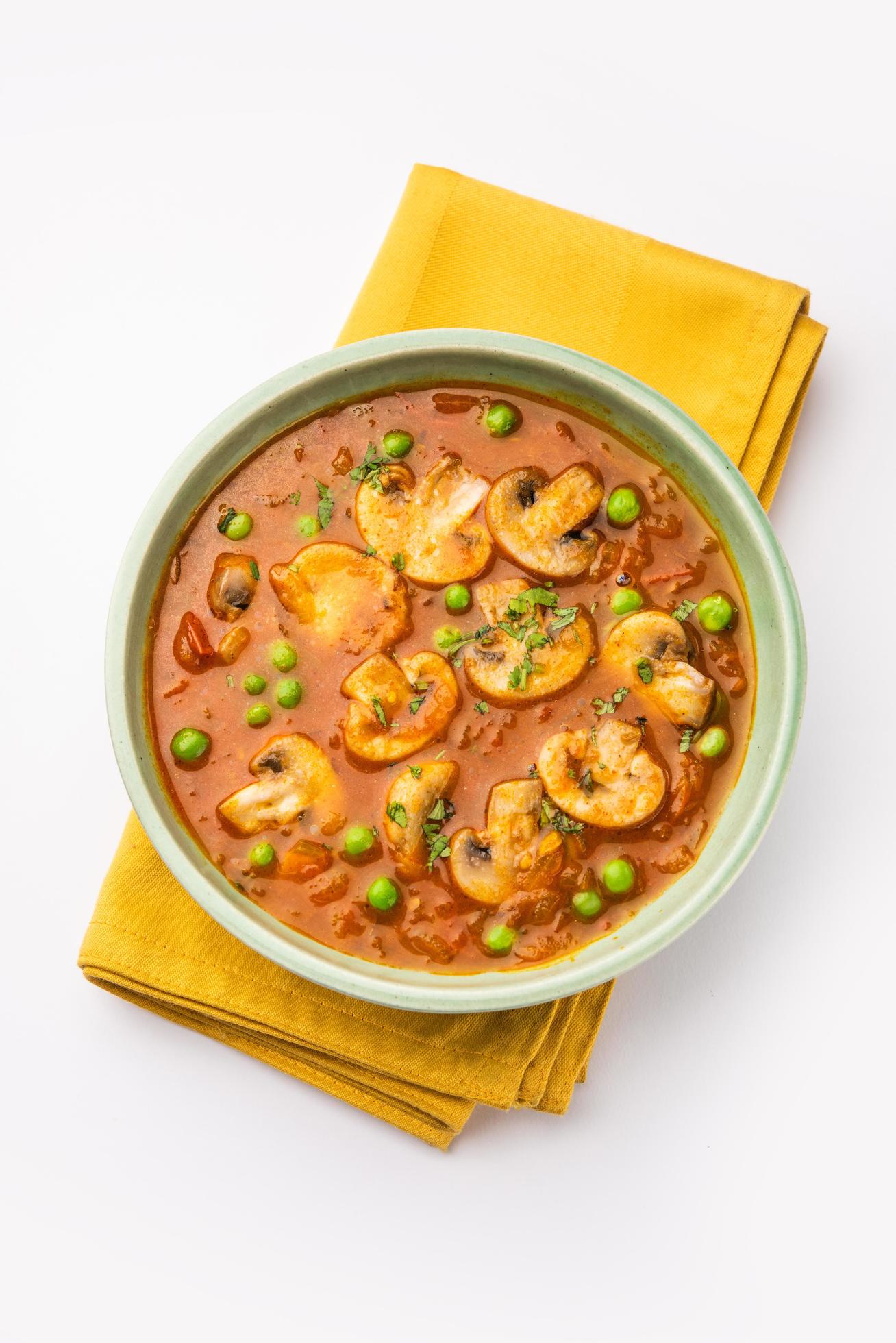 Mushroom and Pea Curry with Roasted Garlic, Indian food served in a bowl Stock Free