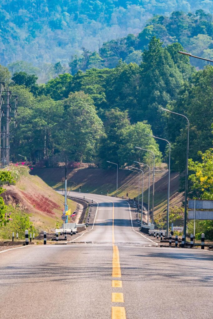 The scene of the road at the dam, with the mountains in the background and a light pole. Stock Free