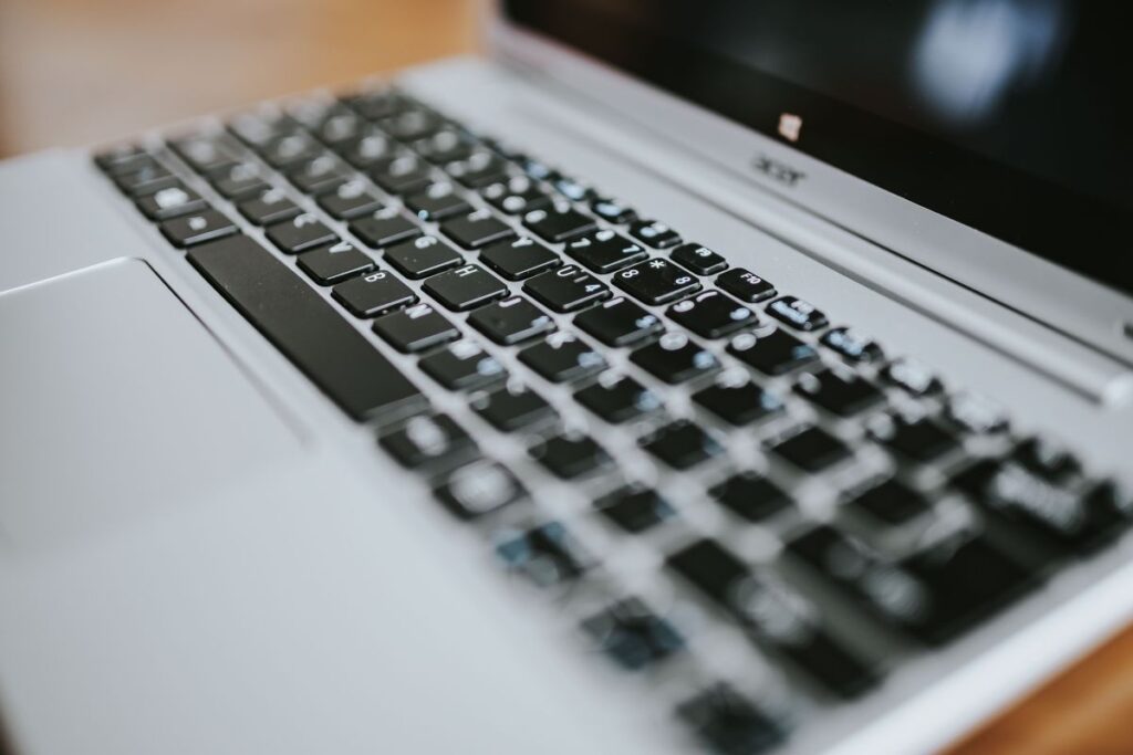 Silver laptop with various items on a table Stock Free