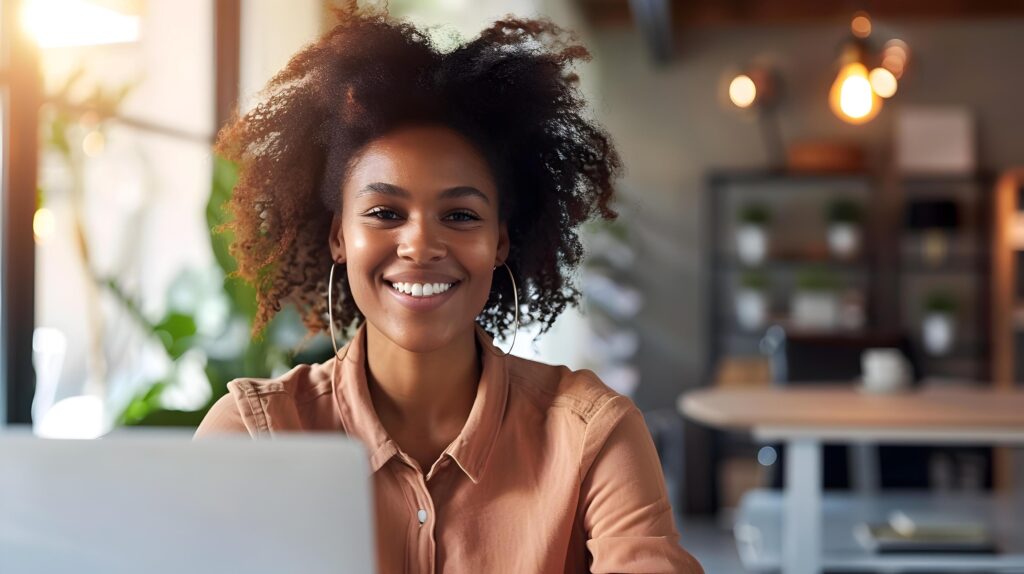 Cheerful Young Business Professional Smiling at Desk in Modern Office Stock Free