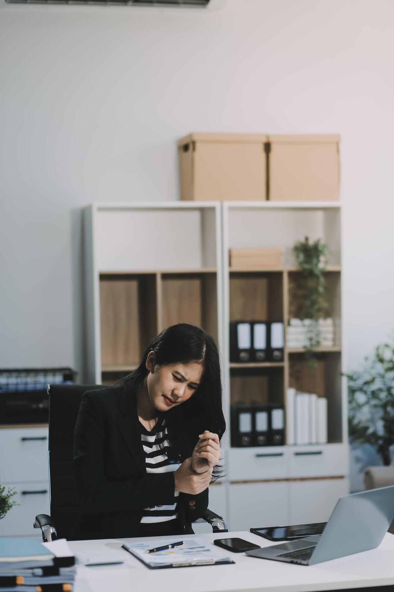 Office asian business woman stretching body for relaxing while working with laptop computer at her desk, office lifestyle, business situation Stock Free