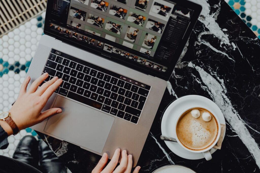 Laptop, coffee and cake with meringue and whipped cream on black marble Stock Free