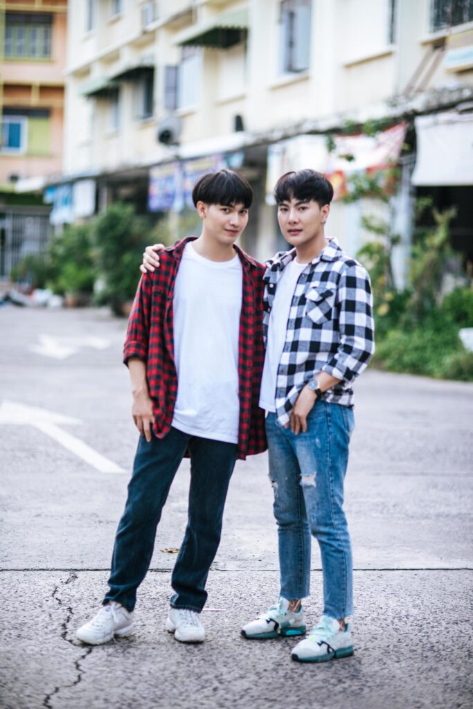 Two loving young men in shirts and standing on the street. Free Photo