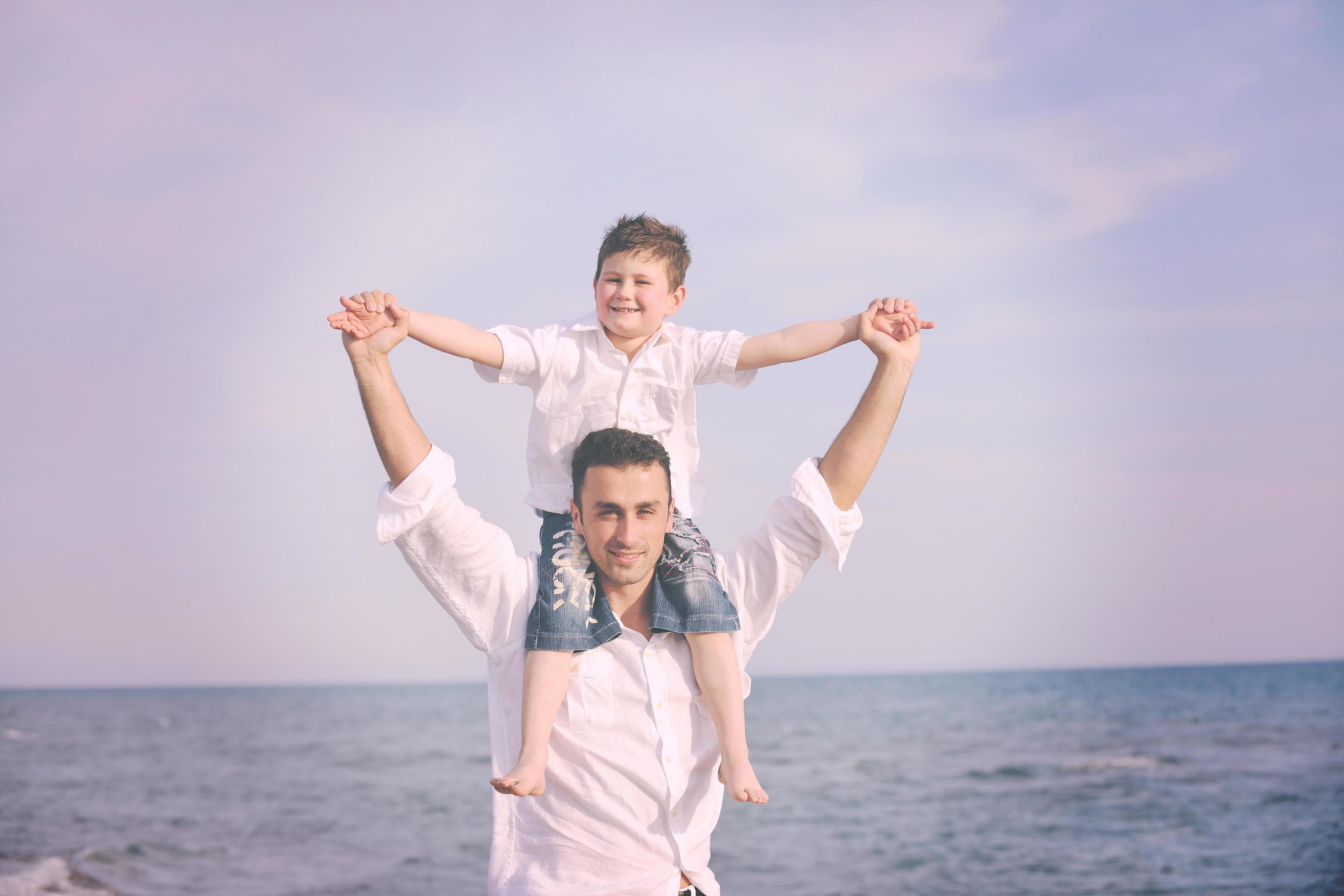 happy father and son have fun and enjoy time on beach Stock Free