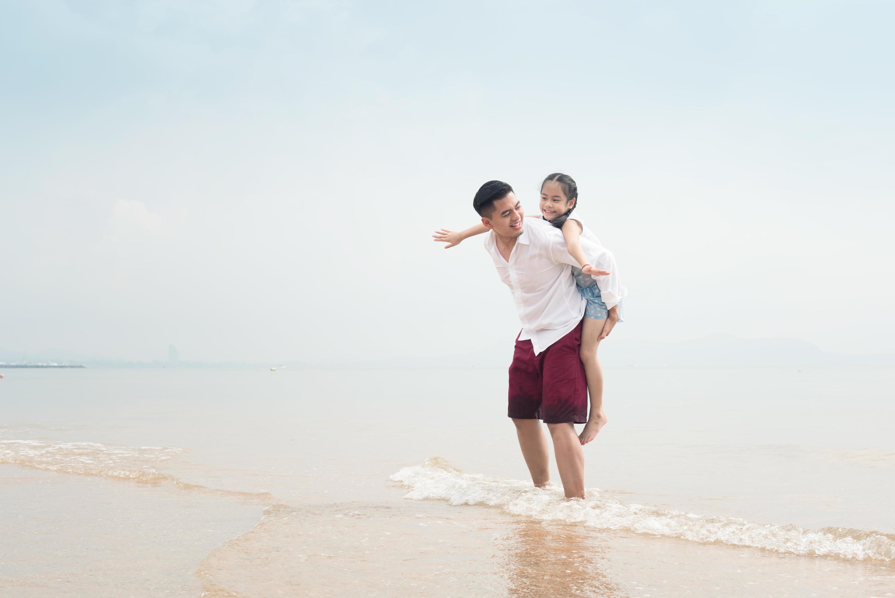 Happy family on beach run and jump at sunset Stock Free